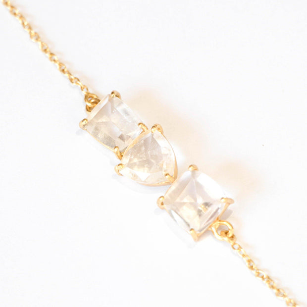 Three beautiful Crystal Quartz stones create a unique balanced bar style bracelet, set on a dainty gold-plated adjustable chain