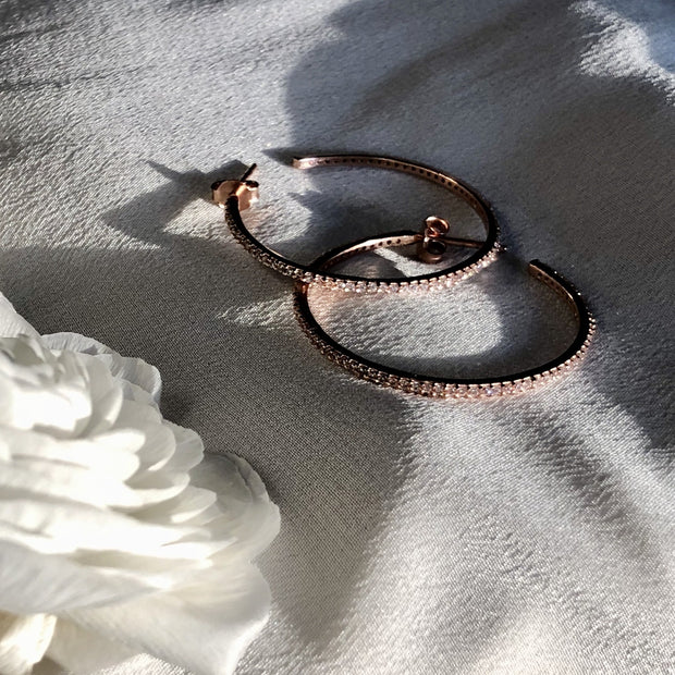 Simple, elegant and stylish. These easy-to-wear medium sized hoops are available in sterling silver or 14 carat gold / rose gold plating. Featuring small cubic zirconia stones set in a pave style