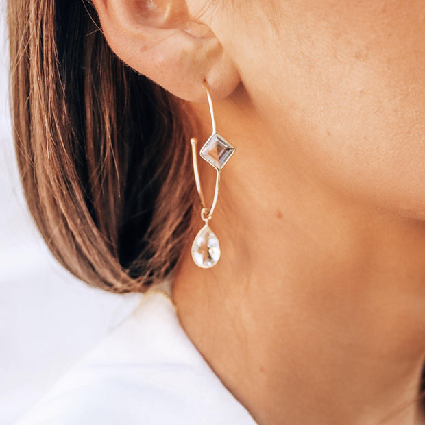 These charming hoop earrings are handmade in sterling silver and 14 carat gold plating and feature crystal quartz semi-precious gemstones