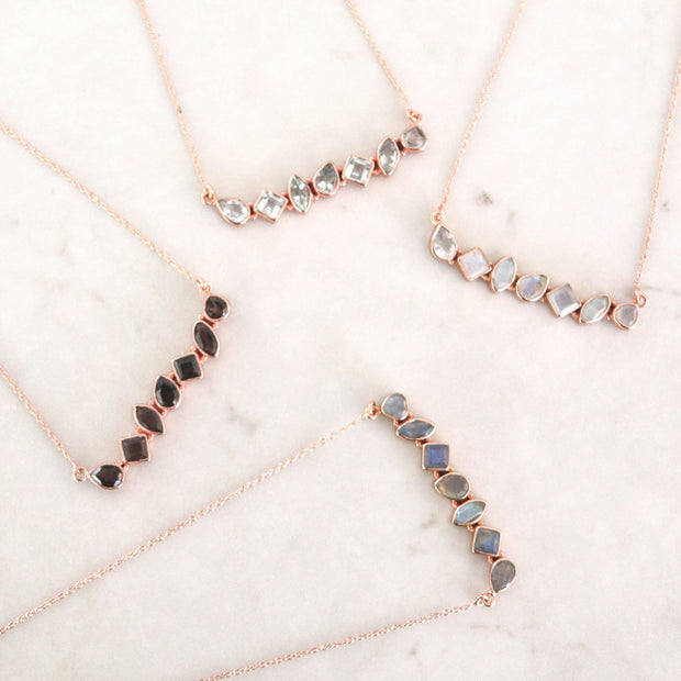 This unique necklace features an array of semi precious Labradorite stones, set in a bar style and handmade in sterling silver and 14 carat rose gold plating