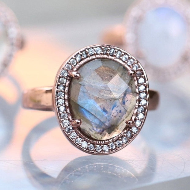 A beautiful solitaire rose-cut semi-precious  Labradorite gemstone is set in a halo of pave cubic zirconias