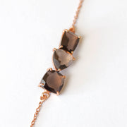 Three Smokey Quartz stones are each cut in unique shapes and placed together to create a unique balanced bar style bracelet. Set on a dainty rose gold-plated adjustable chain