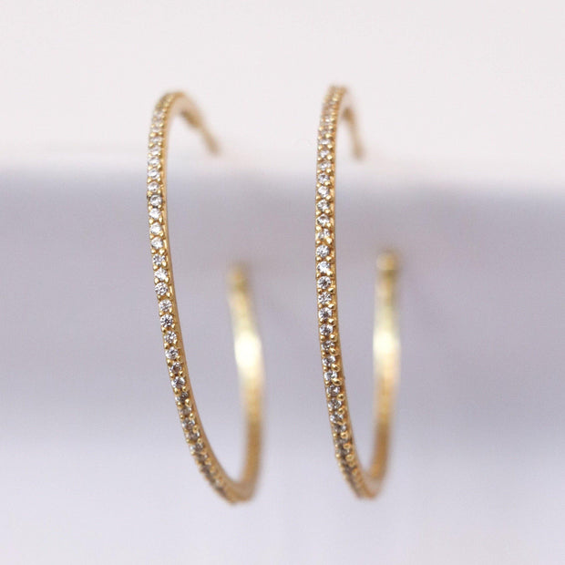 Simple, elegant and stylish. These easy-to-wear medium sized hoops are made in sterling silver 14 carat gold plating. Featuring small cubic zirconia stones set in a pave style
