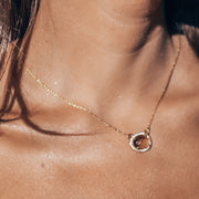 This beautiful pendant features a naturally shaped Smokey Quartz semi-precious gemstone surrounded by a halo of pave set cubic zirconias set on a dainty adjustable chain