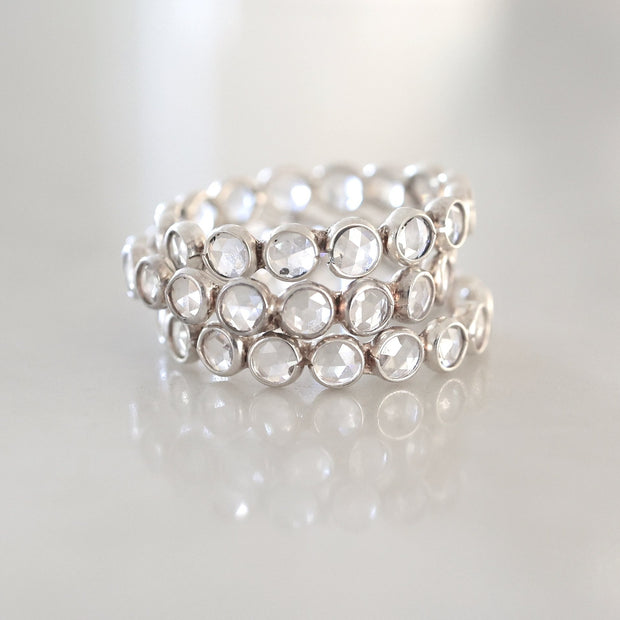 Round crystal stones are set together to create a beautiful band ring that wraps elegantly around the finger. This ring is perfect for wearing solo, stacking many together or with another style of ring for a statement look