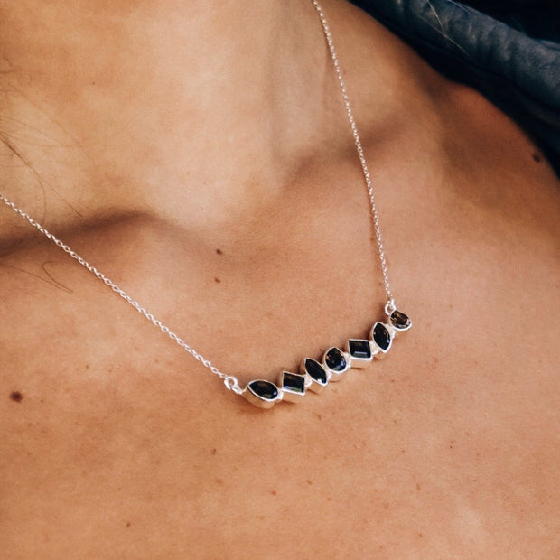 An array of mixed shaped Smokey Quartz stones create a bold bar style necklace set in sterling silver