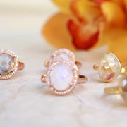 A beautiful Rainbow Moonstone rose-cut stone is surrounded by a halo of pave set cubic zirconias